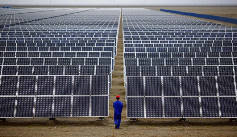 A worker inspects solar panels at a solar farm in Dunhuang, 950km northwest of Lanzhou, Gansu Province
